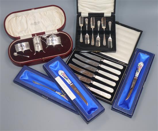 A George V cased silver three piece condiment set, Birmingham, 1924 and five other plated cased items of cutlery.